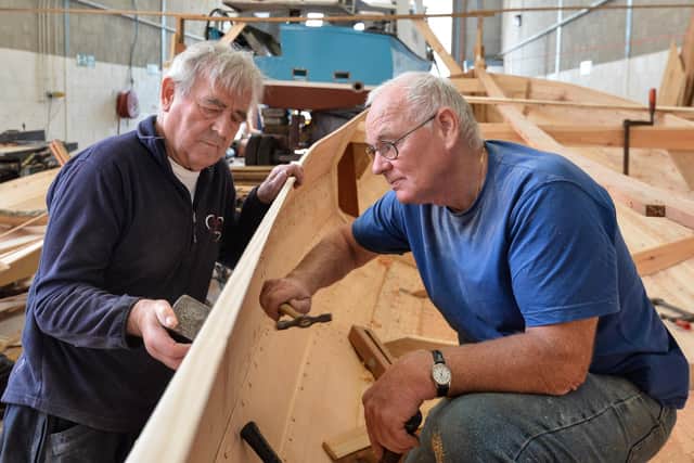 Joe Gelsthorpe, left, and John Clarkson work on a coble restoration.