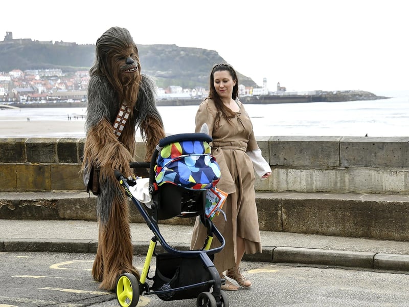 Chewbacca and Princess Leia and a baby head to the festival in 2019.