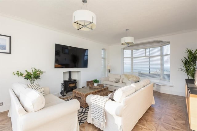 A bay-fronted sitting room with log burner.