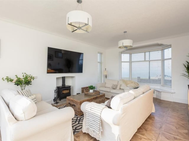 A bay-fronted sitting room with log burner.
