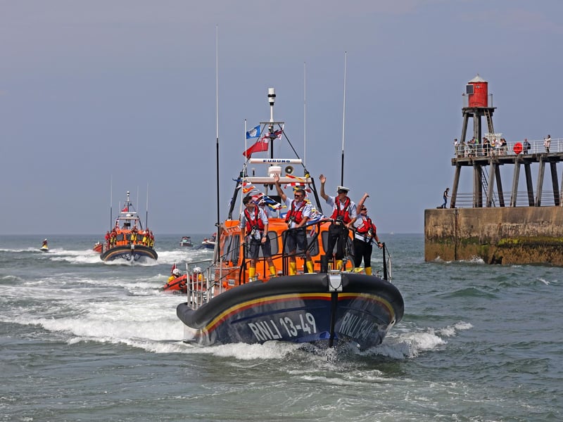 The crew wave to well wishers as the lifeboat enters Whitby harbour.
picture: Ceri Oakes / RNLI