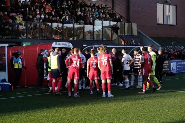 Darlington and Scarborough Athletic are led off the pitch by the match officials