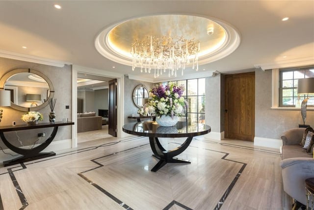 The impressive entrance hall with natural limestone flooring has a solid oak staircase to the first floor.