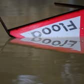 A flood warning sign lies in the water following heavy rain. (Pic credit: Leon Neal / Getty Images)