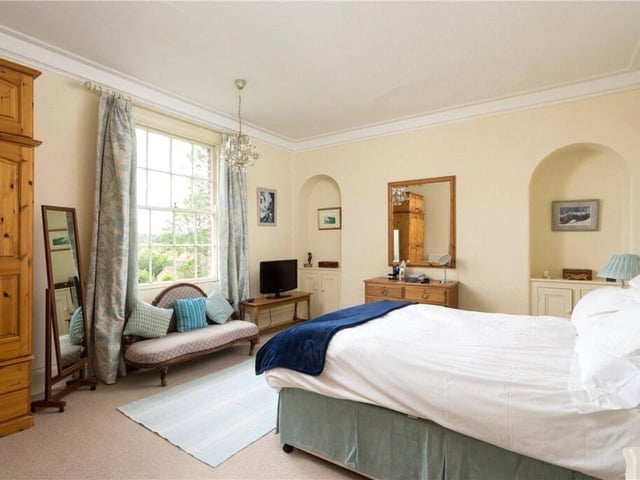 A spacious double bedroom with display alcoves.