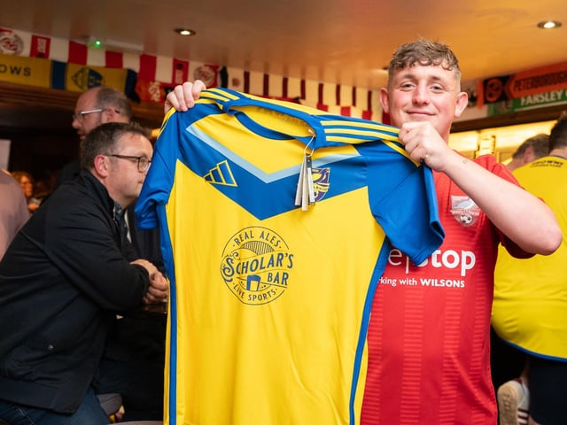 A Boro supporter shows off his new away shirt.