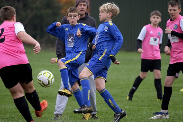 The players from Ayton U13s and Eastfield U13s (blue kit) battle it out