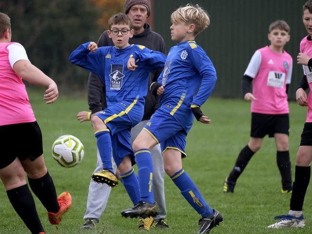 The players from Ayton U13s and Eastfield U13s (blue kit) battle it out