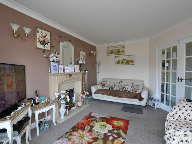 The bright lounge has a feature fireplace with living flame gas fire.