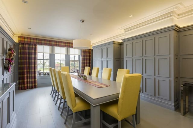 The dining room has wall to wall wood panelling that conceals a drinks cabinet.