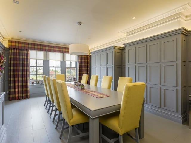 The dining room has wall to wall wood panelling that conceals a drinks cabinet.