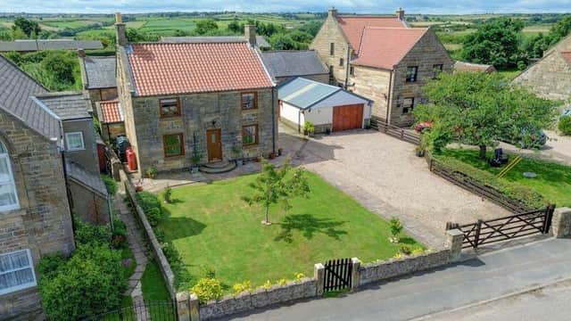An overview of the farmhouse and buildings, in its setting of glorious countryside.
