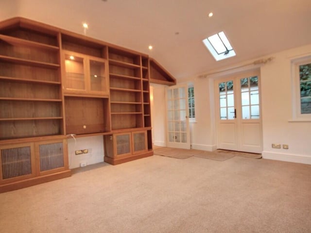 This study or fourth bedroom has French doors to the garden, and fitted cupboards and shelving to one wall.