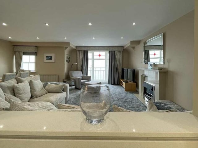 A 'hatch' view of the spacious lounge, with feature fireplace.