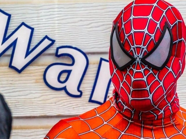 Spiderman poses for a picture before going into the sea.