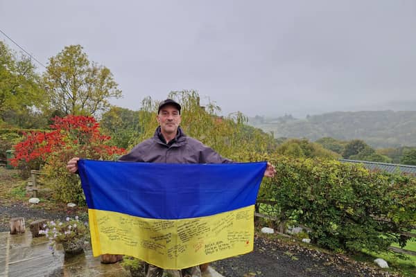 Michael Betoin at home in Grosmont with a flag signed by his Ukrainian friends