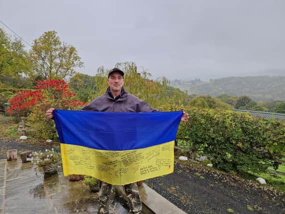Michael Betoin at home in Grosmont with a flag signed by his Ukrainian friends