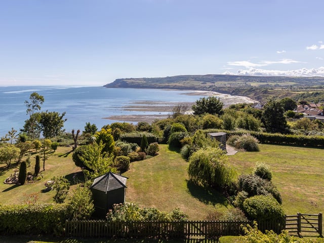 Established trees, shrubs and a summer house add to the appeal of the enclosed garden.