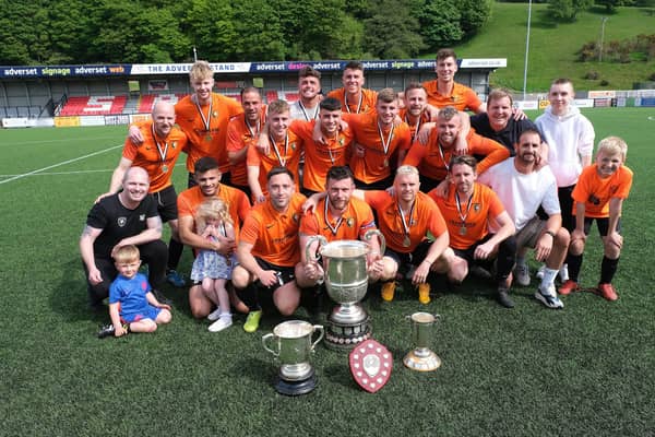 Edgehill FC line up with their trophies from the 2021-22 season