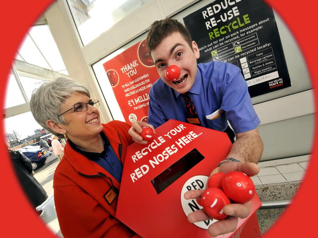 Lindsay Woodhead(L) looks on as Gavin Buchan drops dozens of Red Nose Day noses into the recycling collection box, at Sainsbury's Falgrave store. 091271b, pic by Andrew Higgins