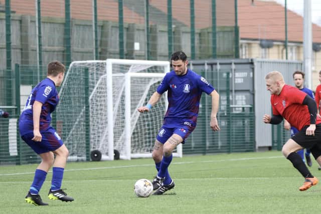 A Pandas player brings the ball clear of the visitors.