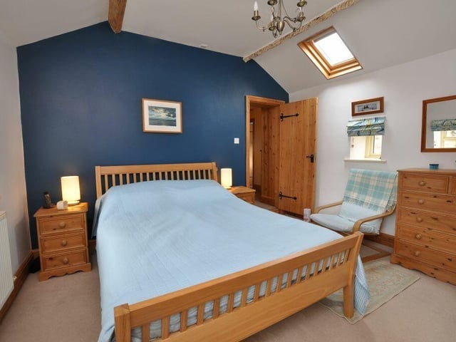 A beamed double bedroom within the property.