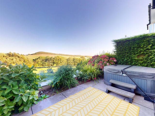 From this elevated patio, the hot tub is in a great spot for occupants to enjoy the scenery.