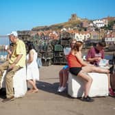 People eat fish and chips and take away food on a busy day in Whitby. (Pic credit: Christopher Furlong / Getty Images)