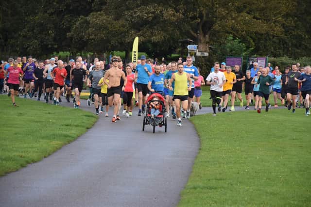 Phill Taylor, with buggy, leads the way in the early stages of the Sewerby parkrun.
