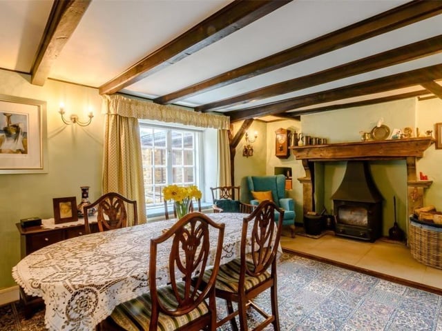 The beamed dining room with stove and fireplace.
