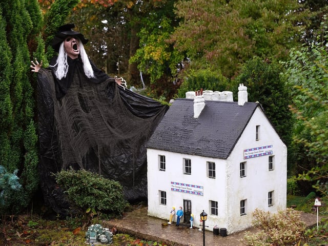 The miniature village looks so intricate and small next to the spooky decor.