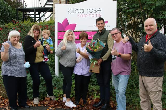 Judith is pictured receiving her flowers from Saint Cecilia’s Care Group Director Aaron Padgham and with family and friends outside the home.