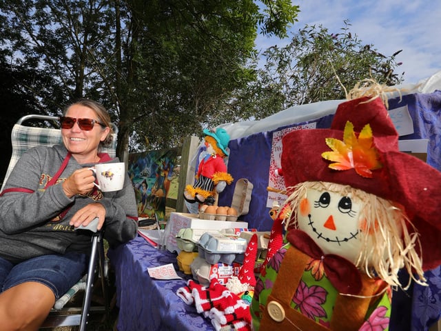 Julie Smith takes a break with her scarecrows. picture: Richard Ponter