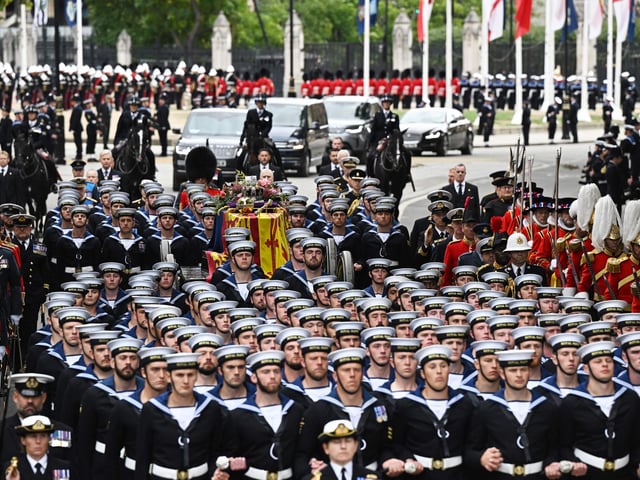 Royal Navy saliors take the coffin of Queen Elizabeth II, draped in a Royal Standard and adorned with the Imperial State Crown and the Sovereign's orb and sceptre on the State Gun Carriage of the Royal Navy to Westminster Abbey for the State Funeral Service for Britain's Queen Elizabeth II. (Photo by Oli SCARFF / AFP) (Photo by OLI SCARFF/AFP via Getty Images)