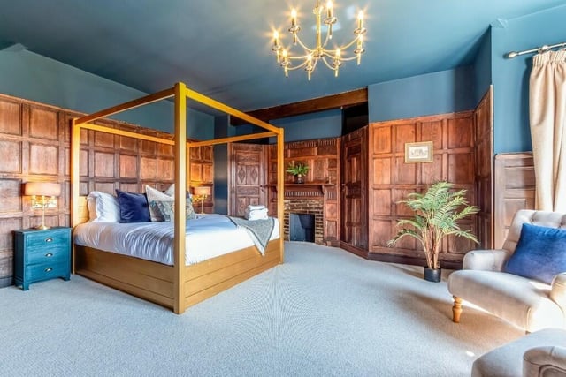 A fabulous double bedroom with wall panelling and fireplace.