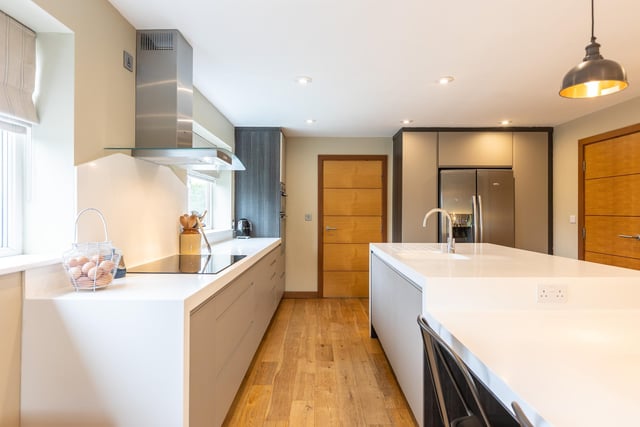 The open plan kitchen has bespoke fitted units and a central island.