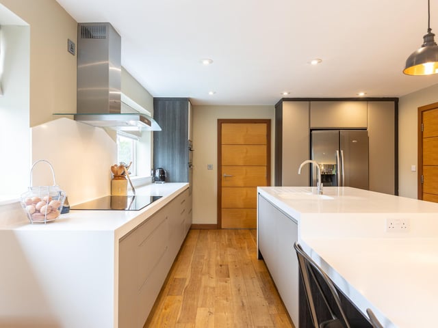 The open plan kitchen has bespoke fitted units and a central island.