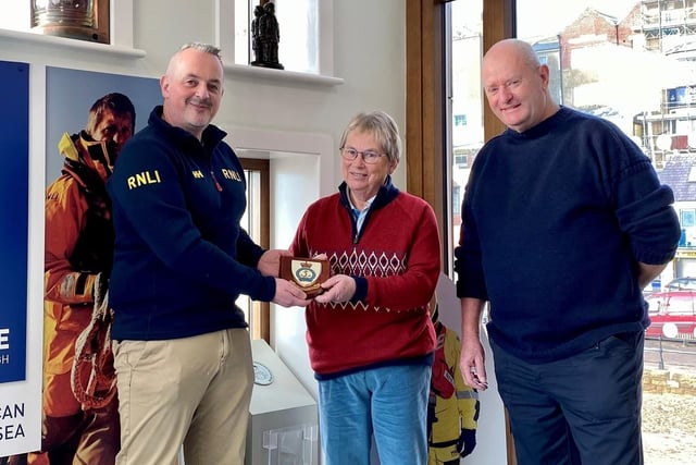 L-R Area Lifesaving Manager, Dave Scott, presents Miss Anne Lawson with a commemorative plaque, accompanied by Lifeboat Operations Manager Roger Buxton.