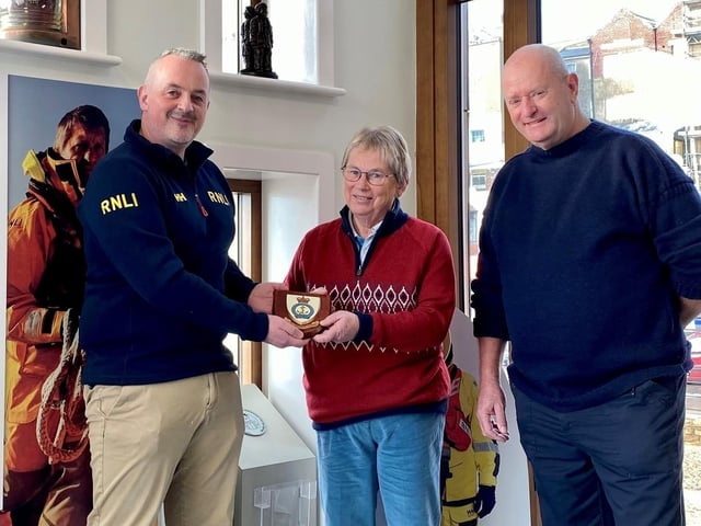 L-R Area Lifesaving Manager, Dave Scott, presents Miss Anne Lawson with a commemorative plaque, accompanied by Lifeboat Operations Manager Roger Buxton.