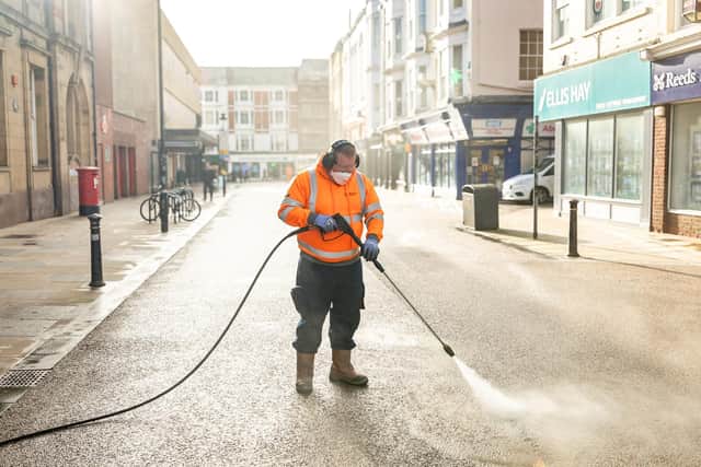 A waste and street scene officer at North Yorkshire Council jet-washing in Scarborough town centre.