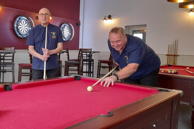 Bev Wynn, right, and Bob Palmer, left, testing out one of their new pool tables in the refurbished sports bar.