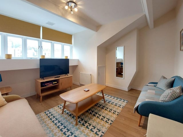 A lounge in one of two top floor modern apartments with sea and castle views.