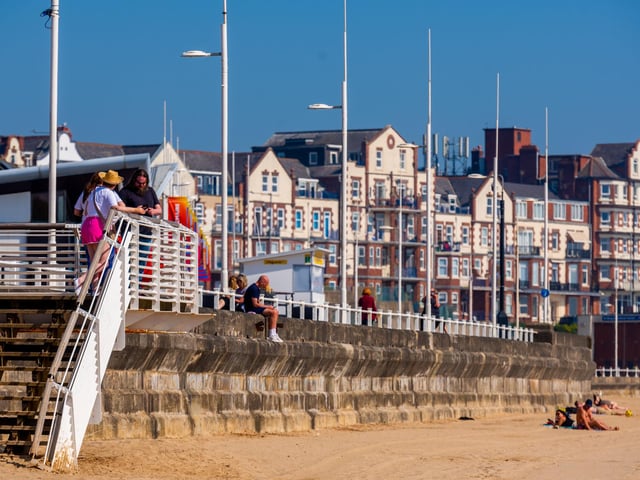 People enjoying the warm weather whilst visiting the seafront.