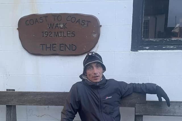 An exhausted Paul Sutherns takes a breather after completing his record-breaking run.