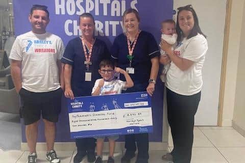 Harley Muscroft with the cheque raised from a sponsored walk, presented to staff at James Cook Hospital.