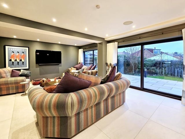 A spacious reception room with plenty of light, and outdoor access through sliding glass doors.