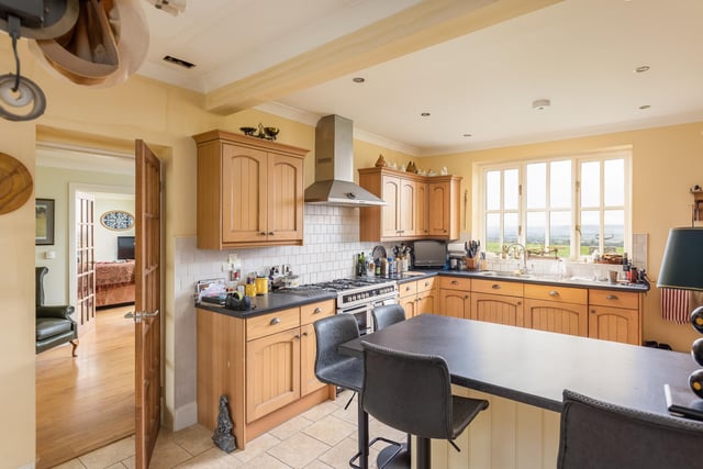 The kitchen has fitted units and a breakfast bar, with a separate utility room.