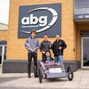 Apprentices from ABG proudly holding their first place trophy next to their winning sopabox.
