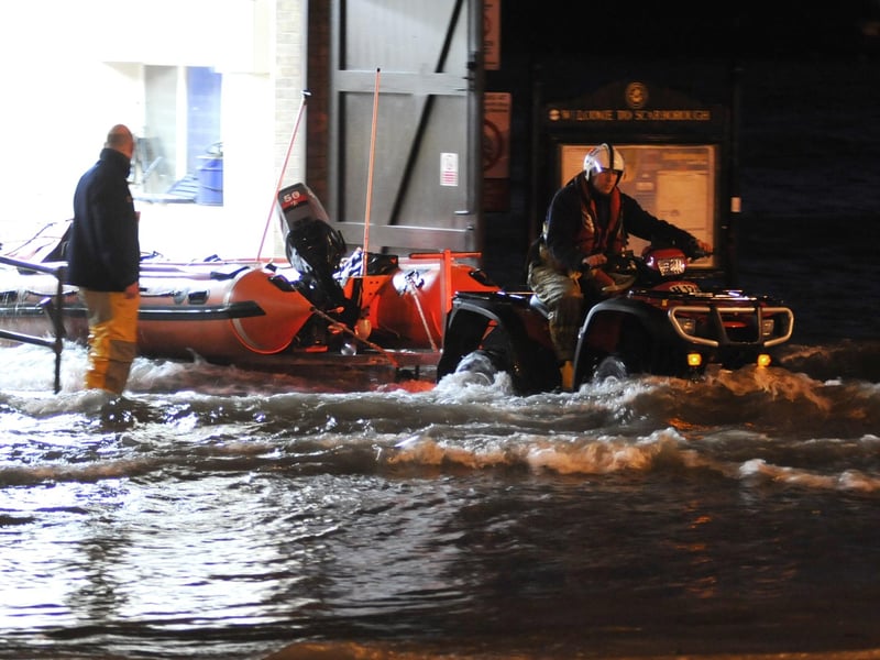 The inshore lifeboat is moved out of the lifeboat house as the tide continues to rise.
