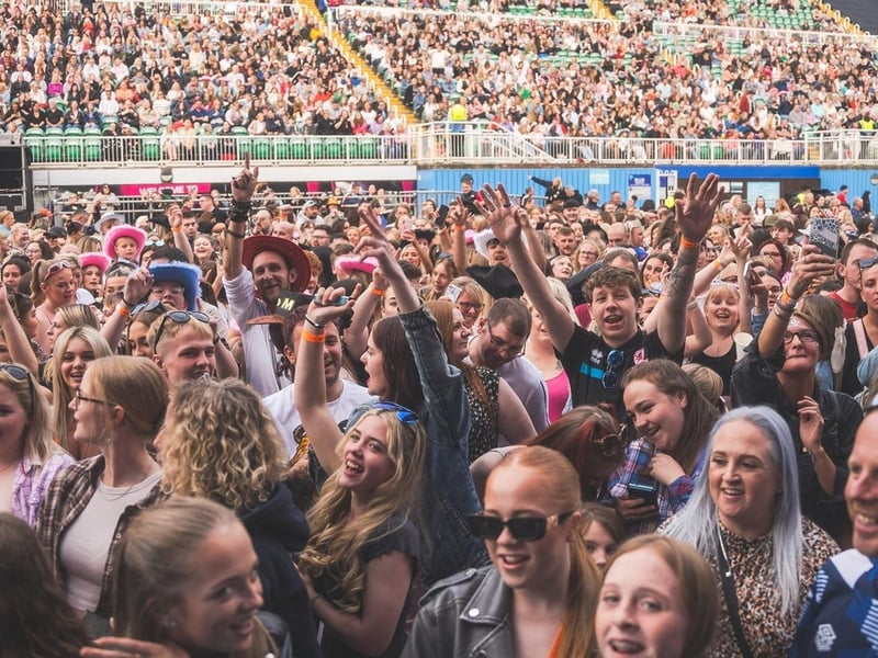 Fans in the standing area enjoying the concert.